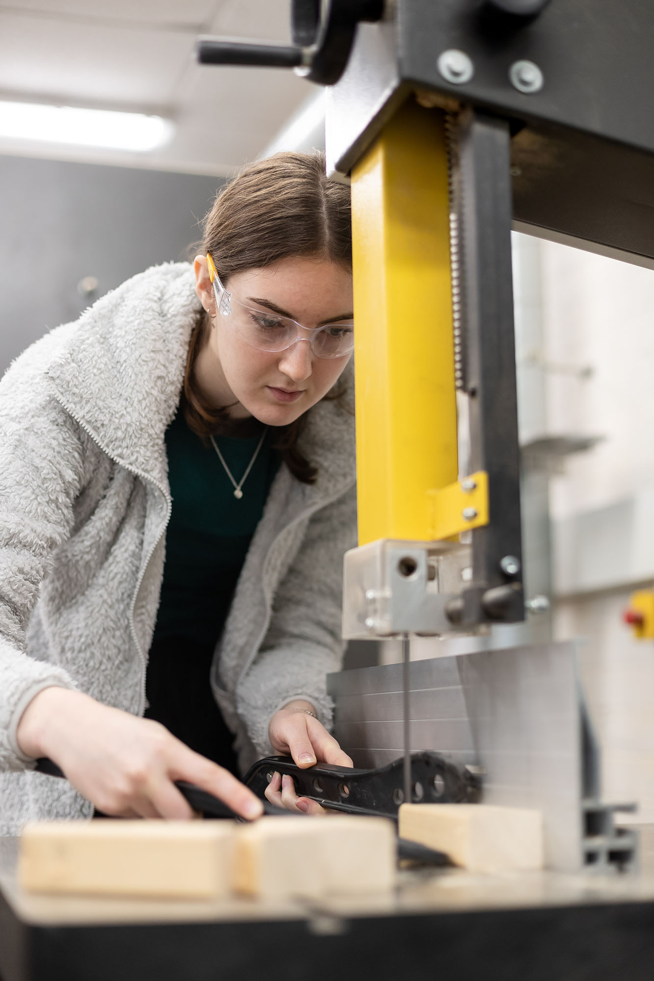 Student operating machine in wood workshop