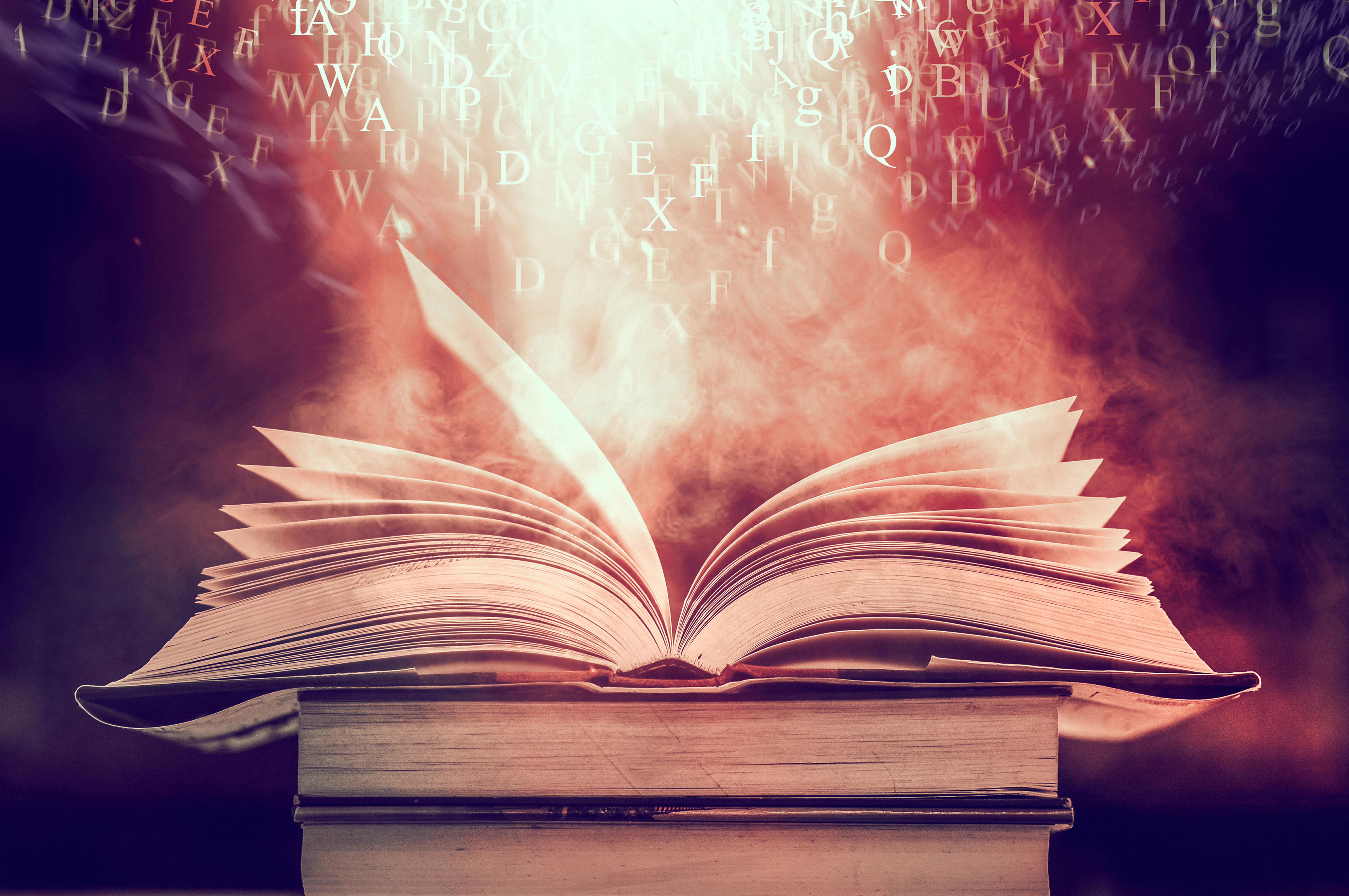 an open book with words and letters coming off the page