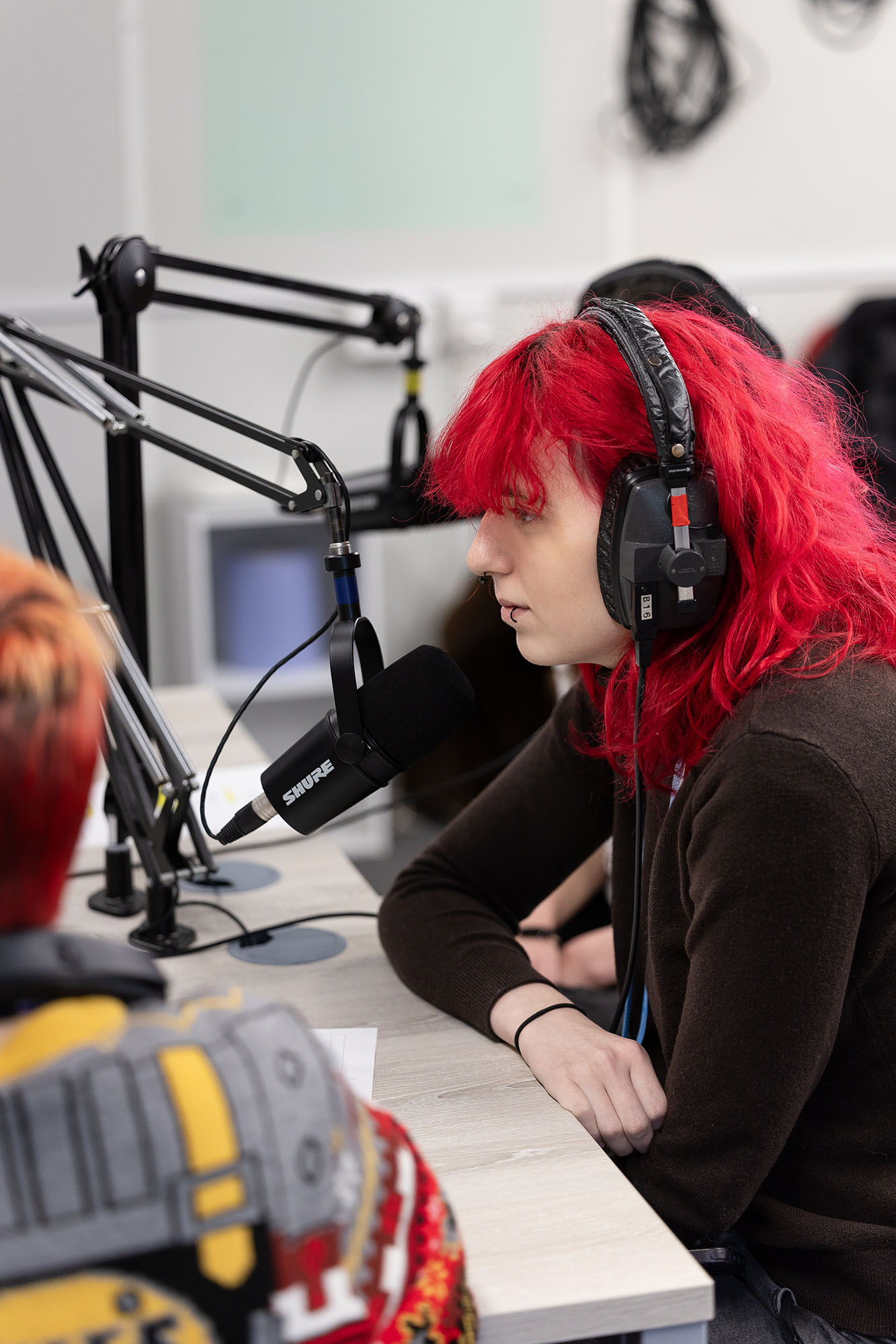 Student in podcast room with headphones