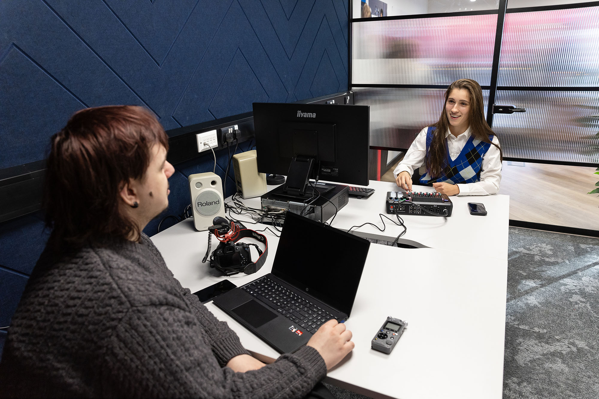 Students having a conversation in radio room.