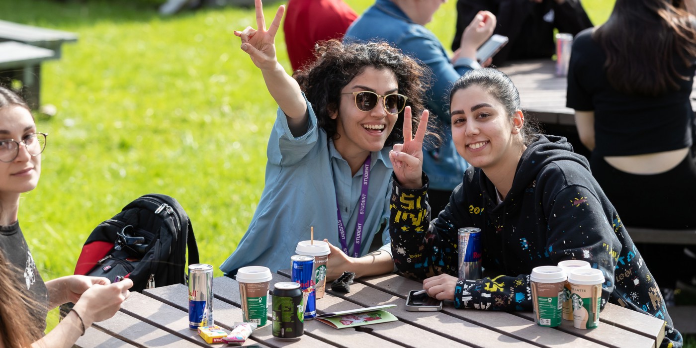 Two students having fun outside in a university social space