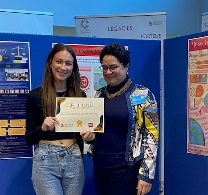 Social Capital competition: Elanor Clarke, the winner, is being presented with the certificate.